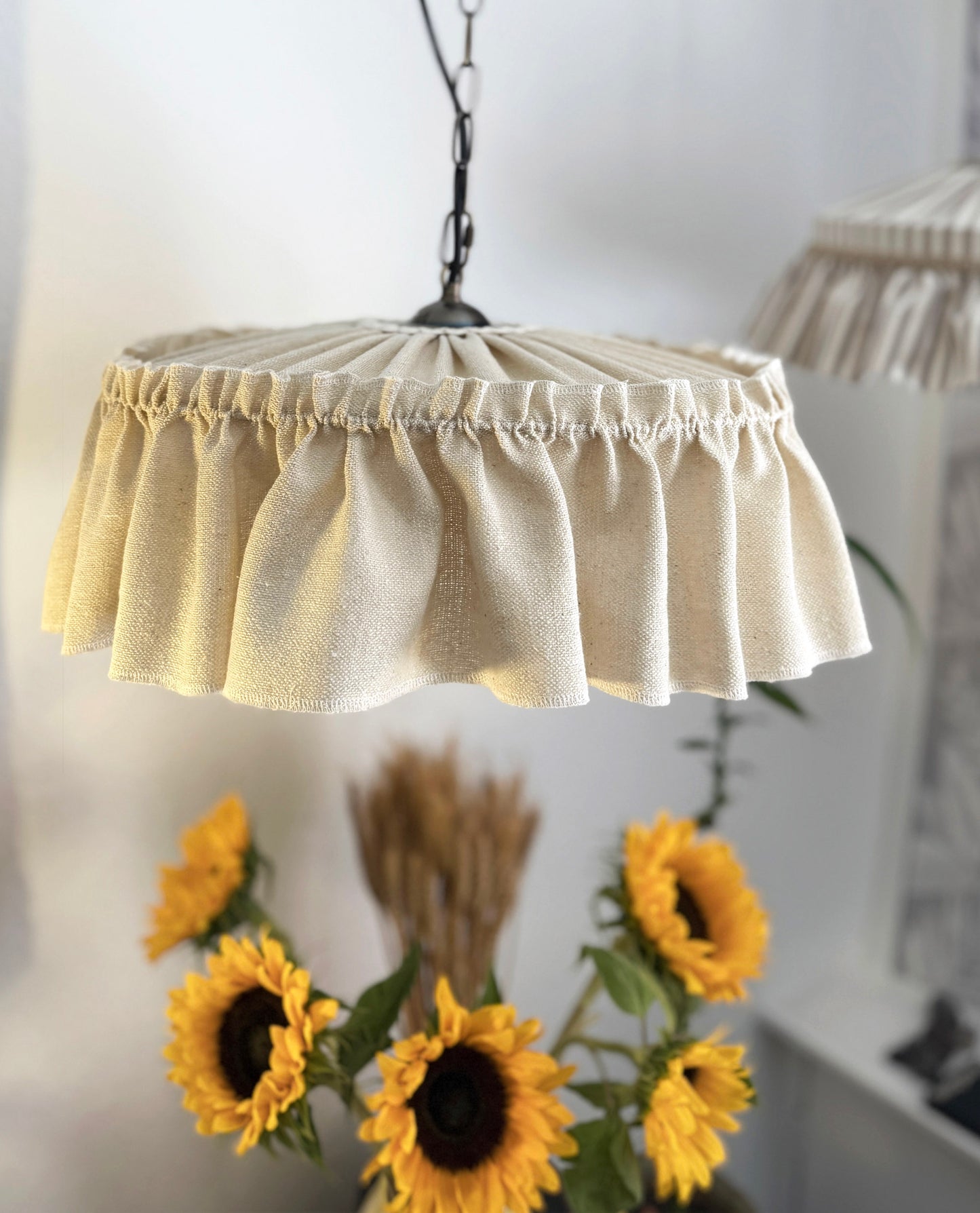 Pendant light with a ruffled beige shade in a home setting.