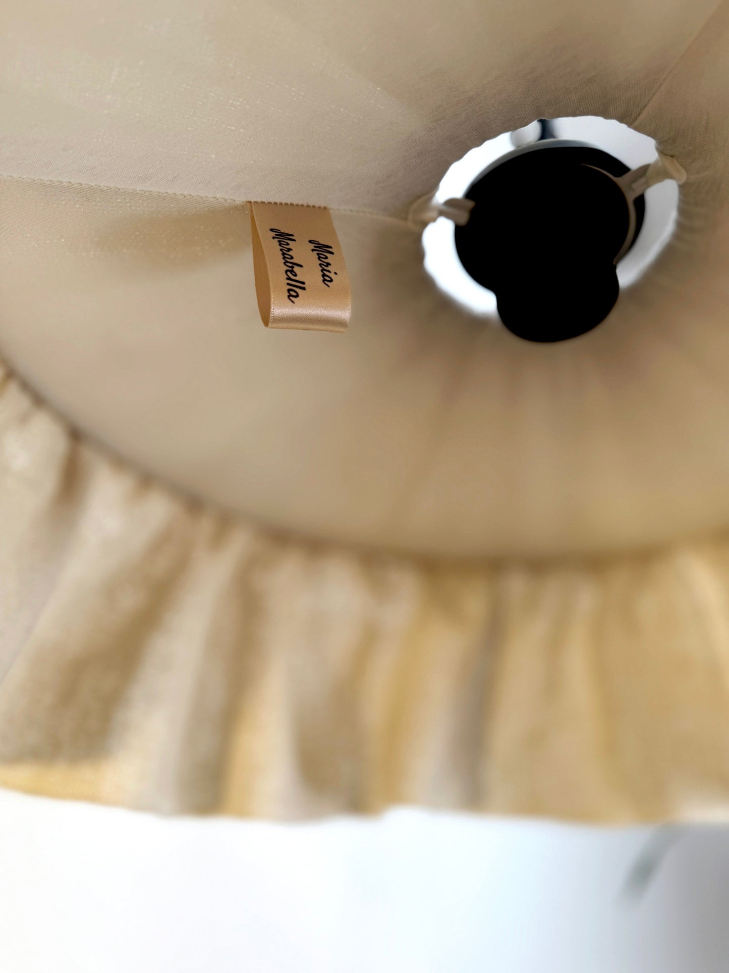 Close-up of a beige lampshade with a brand label with cotton lining