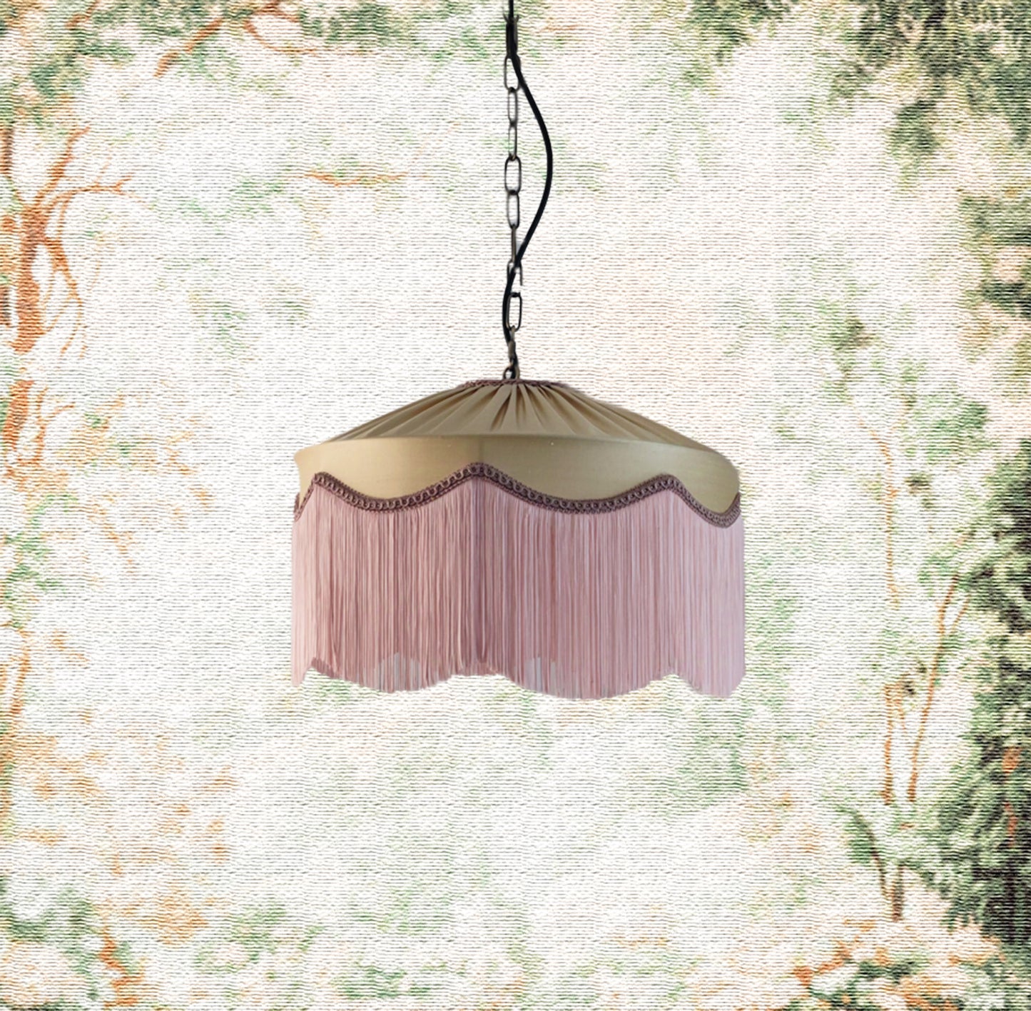 Decorative hanging beige gold silk lamp with pink fringe against a nature-themed background