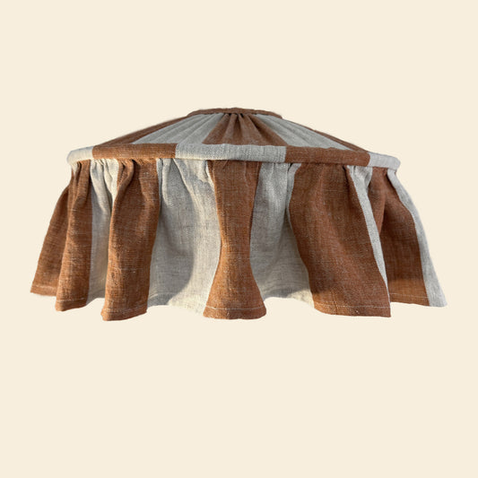 Striped ruffled lampshade with terracotta and gray pattern on a beige background