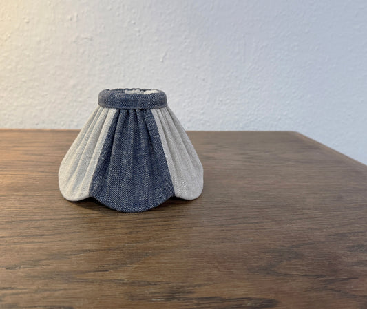 Textured lampshade with blue and gray pattern on a wooden surface