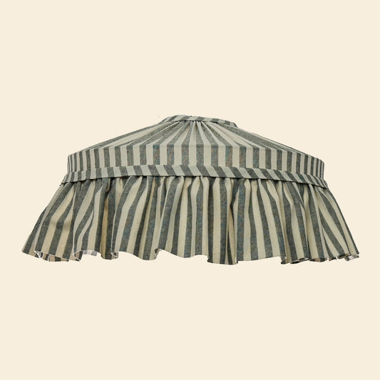 Ruffled lampshade with green and white stripes on a beige background