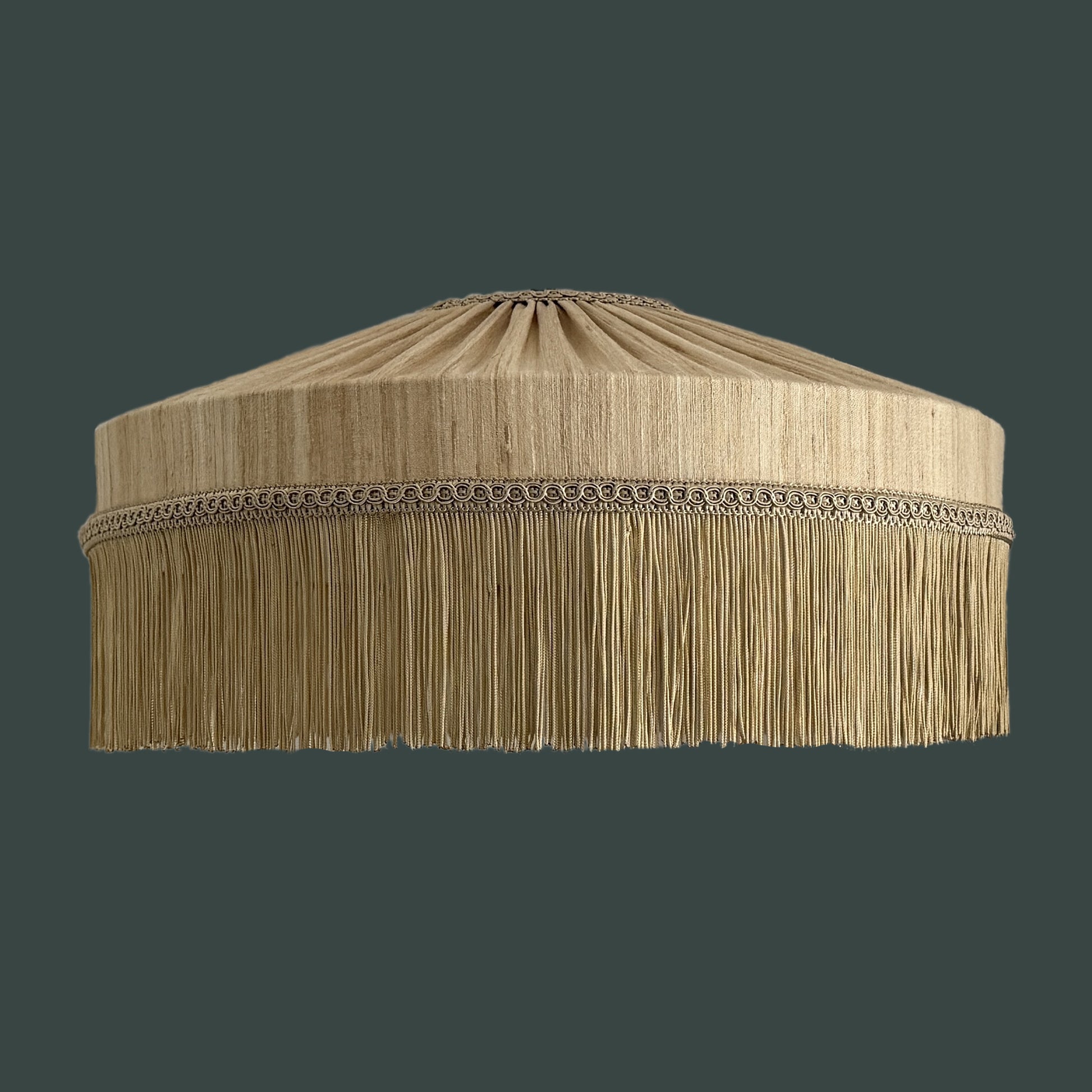 Beige lampshade with fringes on a dark background