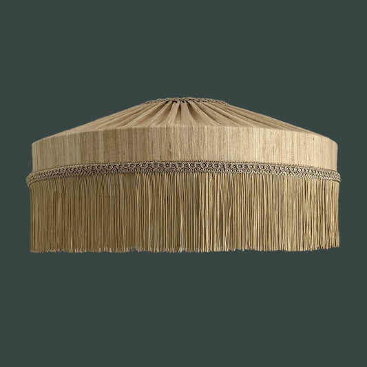 Beige lampshade with fringes on a dark background