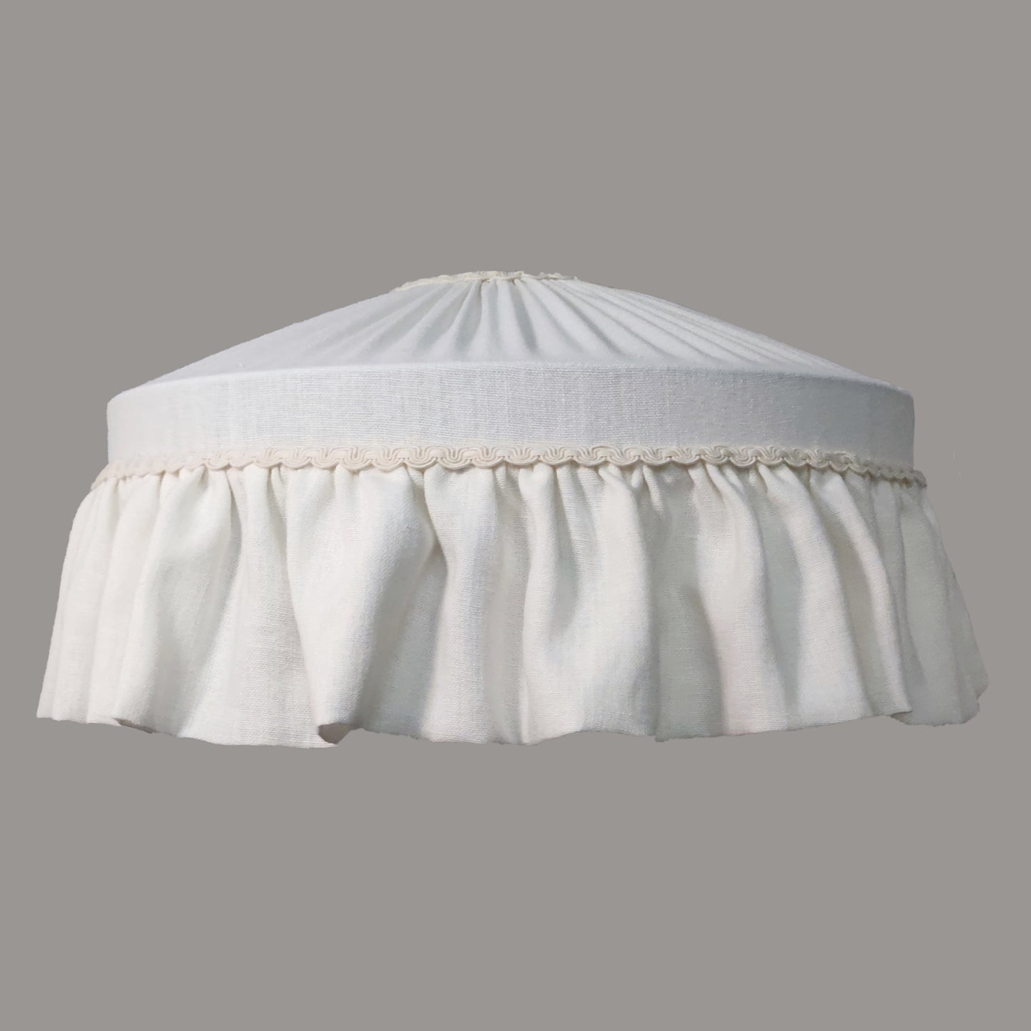 White lampshade with a pleated design on a gray background