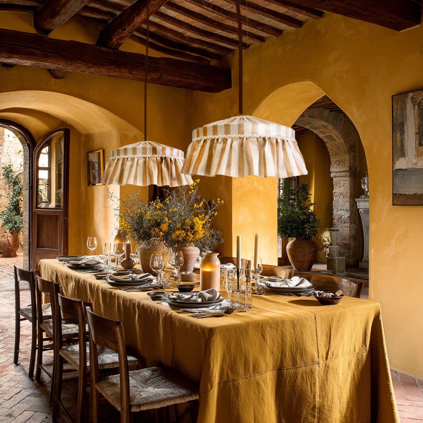 Dining room with a long table set for dinner, rustic decor, and striped pendant lights.